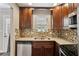 Inviting kitchen featuring granite countertops, a mosaic backsplash, and dark cabinetry at 265 Winding River Dr # G, Sandy Springs, GA 30350