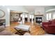 Open-concept living room with hardwood floors, stone fireplace, and access to the dining area at 3290 Coachmans Ne Way, Roswell, GA 30075
