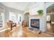 Cozy living room with a stone fireplace, hardwood floors, and two large windows overlooking the backyard at 3290 Coachmans Ne Way, Roswell, GA 30075