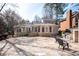 Large brick house has a stone patio with an outdoor fireplace and grill at 3290 Coachmans Ne Way, Roswell, GA 30075