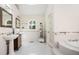 Bright bathroom with dual sinks, tile floor, and soaking tub next to a separate glass door shower at 3290 Coachmans Way Ne Way, Roswell, GA 30075