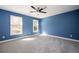 Minimalist bedroom with soft carpet, bright blue walls and natural light from two windows at 3290 Coachmans Ne Way, Roswell, GA 30075