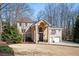 Stately brick two-story home featuring a stone entrance, attached two-car garage, and mature trees at 3290 Coachmans Ne Way, Roswell, GA 30075