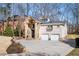 Brick two-story home featuring a stone entrance, two-car garage, and expansive driveway at 3290 Coachmans Ne Way, Roswell, GA 30075