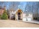 Traditional two-story home featuring an arched entrance, three-car garage, and landscaped yard at 3290 Coachmans Way Ne Way, Roswell, GA 30075