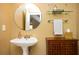 Stylish powder room with a pedestal sink, decorative mirror, storage cabinet and tiled walls at 3290 Coachmans Way Ne Way, Roswell, GA 30075