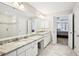 Bathroom featuring double sinks, marble countertops, glass shower and white cabinets at 3500 Fieldstone Xing, Alpharetta, GA 30005