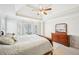 Primary bedroom with large bay windows providing ample natural light, tray ceiling and ceiling fan at 3500 Fieldstone Xing, Alpharetta, GA 30005