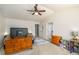 Bright bedroom with a ceiling fan, neutral carpet, dresser, and a large window at 5035 Foxberry Ln, Roswell, GA 30075