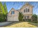 Charming two-story home boasts a two-car garage and manicured landscaping, creating a welcoming curb appeal at 5035 Foxberry Ln, Roswell, GA 30075