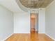 Bright bedroom with hardwood floors, a concrete ceiling, and a hallway leading to the bathroom at 361 17Th St # 1516, Atlanta, GA 30363
