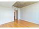 A bright bedroom with hardwood floors, a concrete ceiling, and a hallway with shelving at 361 17Th St # 1516, Atlanta, GA 30363