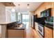Well-lit kitchen with wooden cabinets, a black backsplash, stainless steel appliances, and hardwood floors at 361 17Th St # 1516, Atlanta, GA 30363