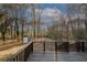 A wooden porch and backyard with mature trees and an additional shed in the far back at 8325 Attleboro Dr, Jonesboro, GA 30238