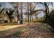 Mature trees line a large backyard with an outbuilding shed and some fencing at 8325 Attleboro Dr, Jonesboro, GA 30238