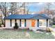 Charming brick home featuring blue shutters, a new roof, and a bright orange front door at 8325 Attleboro Dr, Jonesboro, GA 30238