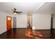 Open-concept living room with hardwood floors, modern ceiling fan, and a bright orange door at 8325 Attleboro Dr, Jonesboro, GA 30238
