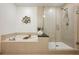 Elegant bathroom with a soaking tub, glass enclosed shower, and neutral tile at 1080 Peachtree Ne St # 2309, Atlanta, GA 30309