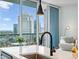 Modern kitchen island with a matte black faucet and view of the living area and balcony at 1080 Peachtree Ne St # 2309, Atlanta, GA 30309