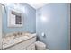 Powder blue bathroom featuring a white single sink vanity with marble countertop and a toilet at 1379 Keys Lake Ne Dr, Brookhaven, GA 30319