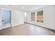 Spacious bedroom with attached bathroom, hardwood floors, white walls, and large windows overlooking the outdoor landscape at 1379 Keys Lake Ne Dr, Brookhaven, GA 30319