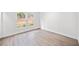 Empty bedroom with hardwood floors, white walls, base trim and windows overlooking outside foliage at 1379 Keys Lake Ne Dr, Brookhaven, GA 30319