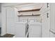 The modern laundry room with modern appliances, floating shelves, and sleek white cabinetry at 1379 Keys Lake Ne Dr, Brookhaven, GA 30319