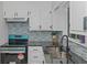 Updated kitchen features white cabinets, gray backsplash, and stainless steel sink at 2128 Jones Nw Rd, Atlanta, GA 30318