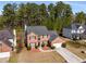 Aerial view of a brick two-story home in a treed neighborhood, with an attached garage at 3876 Elm Trace Ct, Loganville, GA 30052