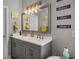 Bathroom vanity with double sinks, gray cabinets, and decorative mirror at 3876 Elm Trace Ct, Loganville, GA 30052