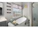 Bathroom features a soaking tub with natural light and gray-toned walls at 3876 Elm Trace Ct, Loganville, GA 30052