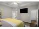 Open Primary bedroom featuring neutral walls, wood floors, tray ceiling, and ensuite bathroom at 3876 Elm Trace Ct, Loganville, GA 30052
