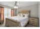 Cozy bedroom with neutral walls, decorative bed frame, and modern ceiling fan with lights at 3876 Elm Trace Ct, Loganville, GA 30052