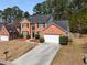 Two-story brick home with a two-car garage, mature trees, and a spacious front yard at 3876 Elm Trace Ct, Loganville, GA 30052