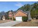 Two-story brick home with an attached two-car garage, and a well-maintained driveway at 3876 Elm Trace Ct, Loganville, GA 30052
