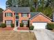 Beautiful two-story brick home featuring an attached two-car garage and manicured landscaping at 3876 Elm Trace Ct, Loganville, GA 30052