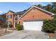 Two-story brick home with an attached garage, well-maintained landscaping, and an inviting entryway at 3876 Elm Trace Ct, Loganville, GA 30052
