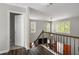 Upstairs hallway with iron railing overlooking living room at 3876 Elm Trace Ct, Loganville, GA 30052