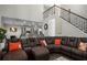 Spacious living room with staircase, open to the kitchen, featuring a large comfortable couch and modern design elements at 3876 Elm Trace Ct, Loganville, GA 30052