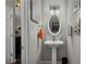 Charming powder room featuring pedestal sink and decorative mirror at 3876 Elm Trace Ct, Loganville, GA 30052