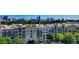 Elevated view of apartments with lush greenery, rooftop parking, and city skyline at 390 17Th Nw St # 2025, Atlanta, GA 30363