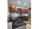 Modern kitchen with stainless steel appliances, dark countertops, and brown cabinets at 390 17Th Nw St # 2025, Atlanta, GA 30363