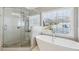 Bright bathroom featuring a soaking tub, glass shower, and large window at 2298 Greenglade Ne Rd, Atlanta, GA 30345