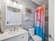 Gray bathroom with white vanity, colorful shower curtain, and decorative shelving at 2298 Greenglade Ne Rd, Atlanta, GA 30345
