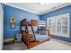 Cozy blue bedroom featuring a wooden bunk bed with ladder and a window with plantation shutters at 2298 Greenglade Ne Rd, Atlanta, GA 30345