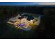 Aerial view of luxury home at dusk featuring a grand driveway and backyard pool and manicured lawn at 4100 Oak Hill Rd, Douglasville, GA 30135