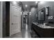 Bathroom featuring sleek gray tile, double vanity with stone countertop, chandelier, and modern fixtures, offering a luxurious spa-like experience at 4100 Oak Hill Rd, Douglasville, GA 30135