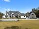 Beautiful exterior view of a grand two-story home with a stone and white painted brick facade and manicured lawn at 4100 Oak Hill Rd, Douglasville, GA 30135
