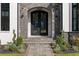 Close-up of the arched front entrance with intricate wrought iron double doors and stone walkway at 4100 Oak Hill Rd, Douglasville, GA 30135