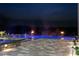 Backyard pool at dusk featuring integrated fire bowls and spa surrounded by stone paver patio at 4100 Oak Hill Rd, Douglasville, GA 30135